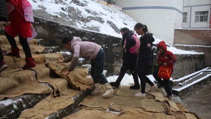 [图]雪大路滑 粮站保管员用废旧麻袋为学生铺就百米“爱心路”